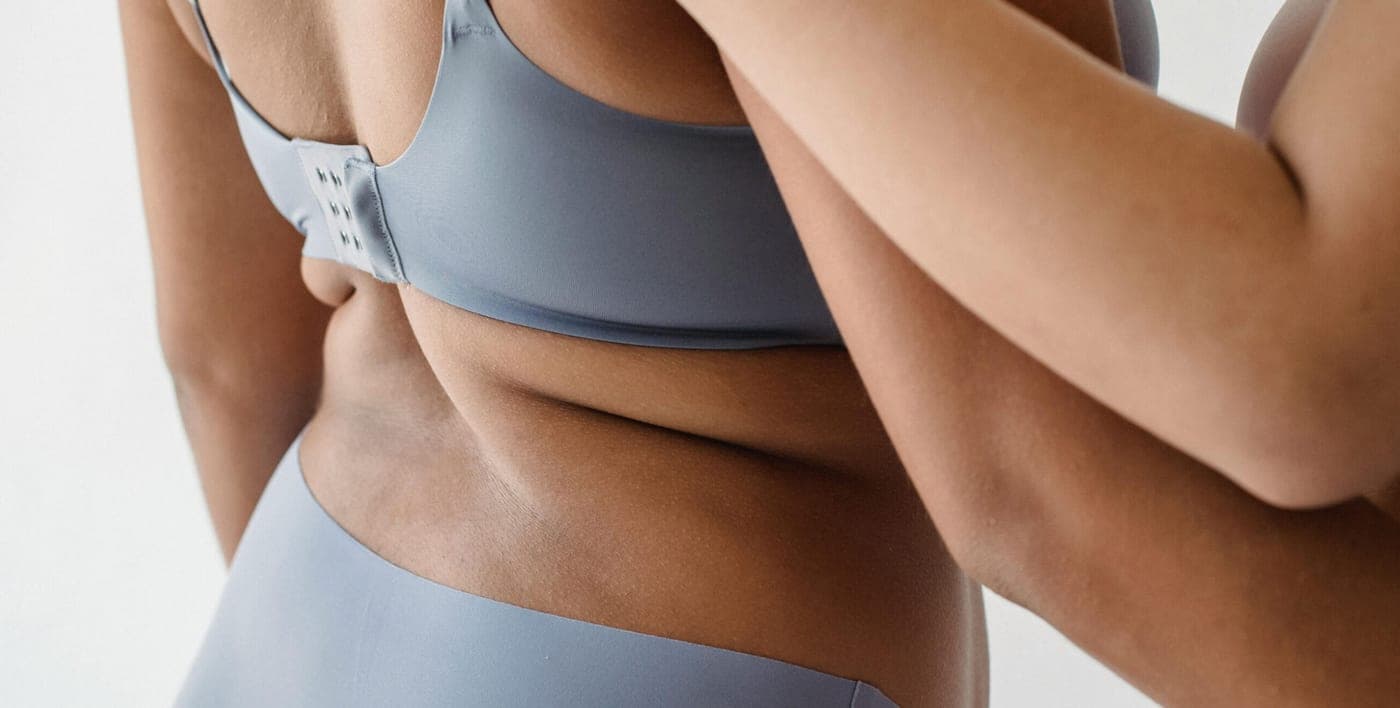Mujer con top deportivo, cintura y brazos