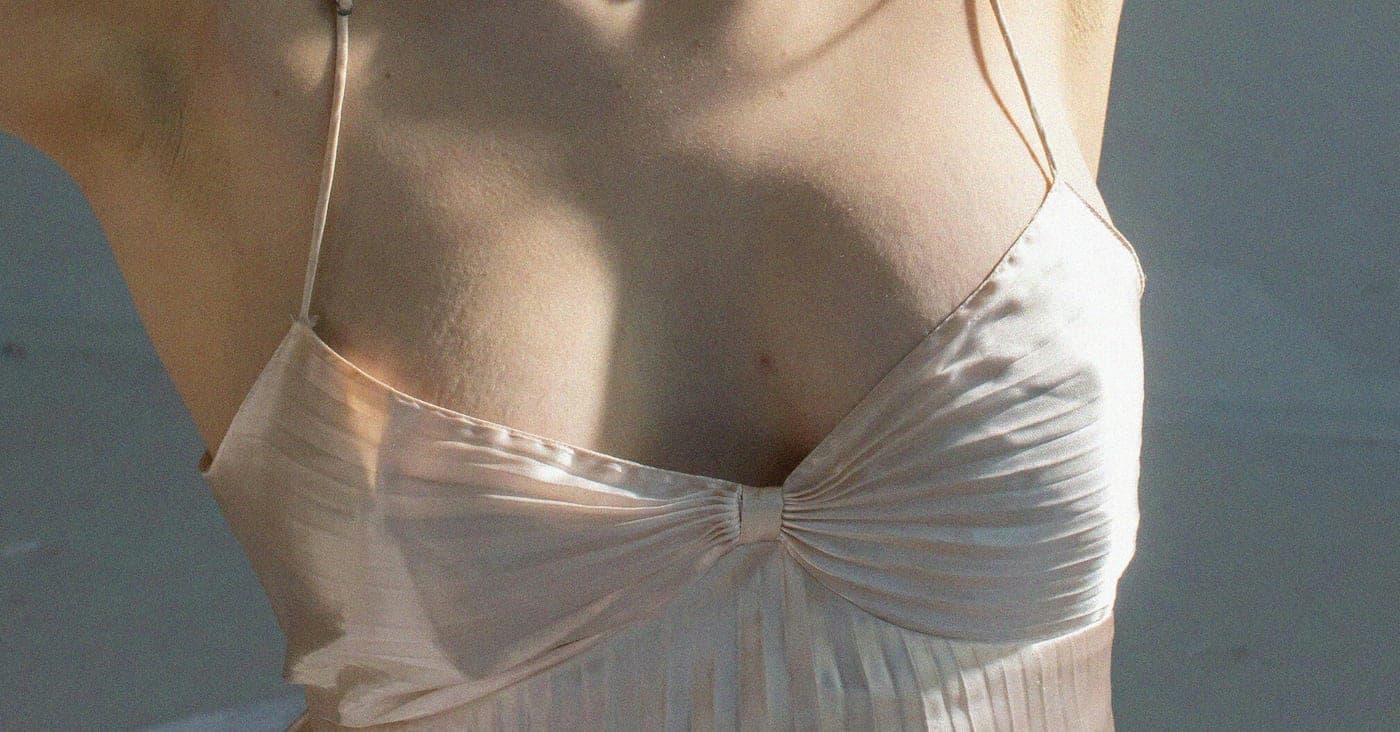 Mujer con camisola de seda, pecho y hombros