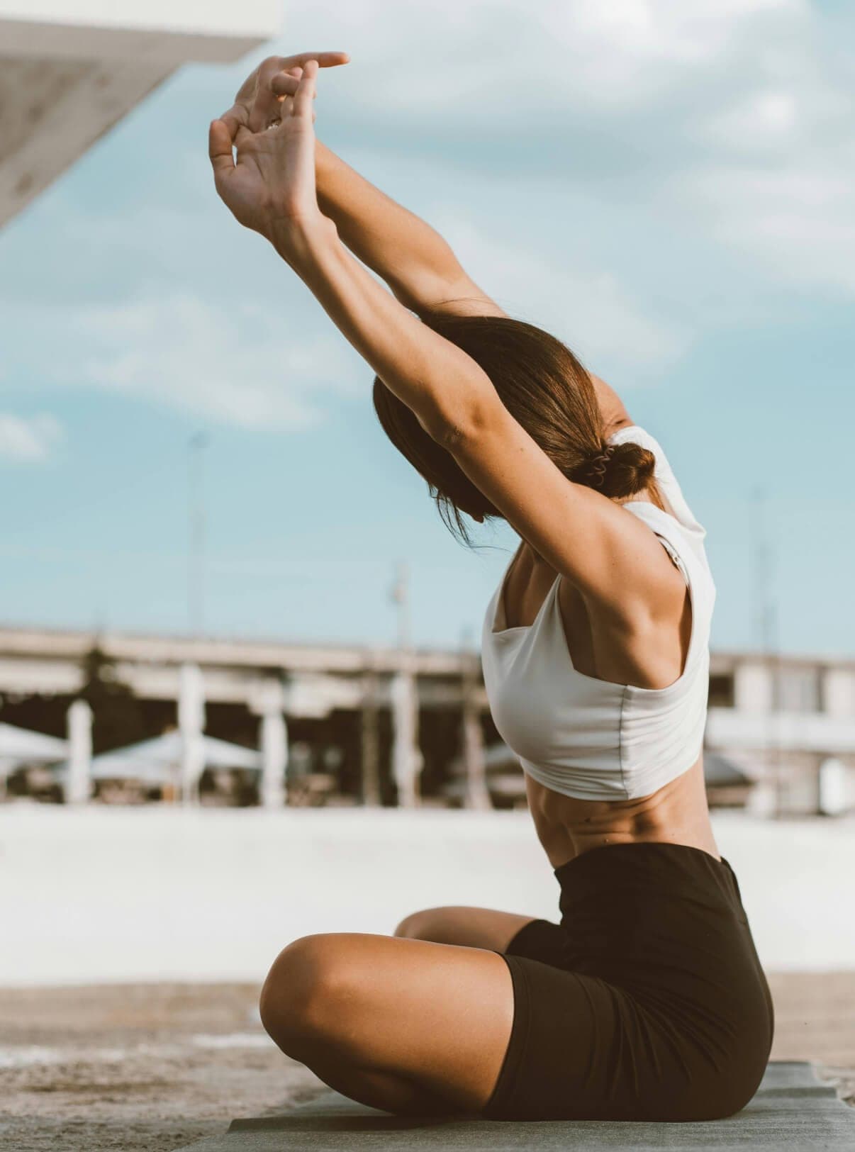 Mujer estirándose al aire libre junto al agua